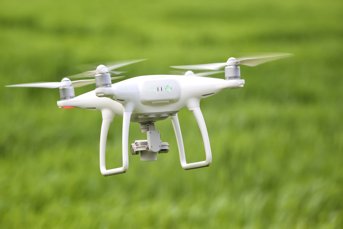 Modern Quadcopter Flying over Field