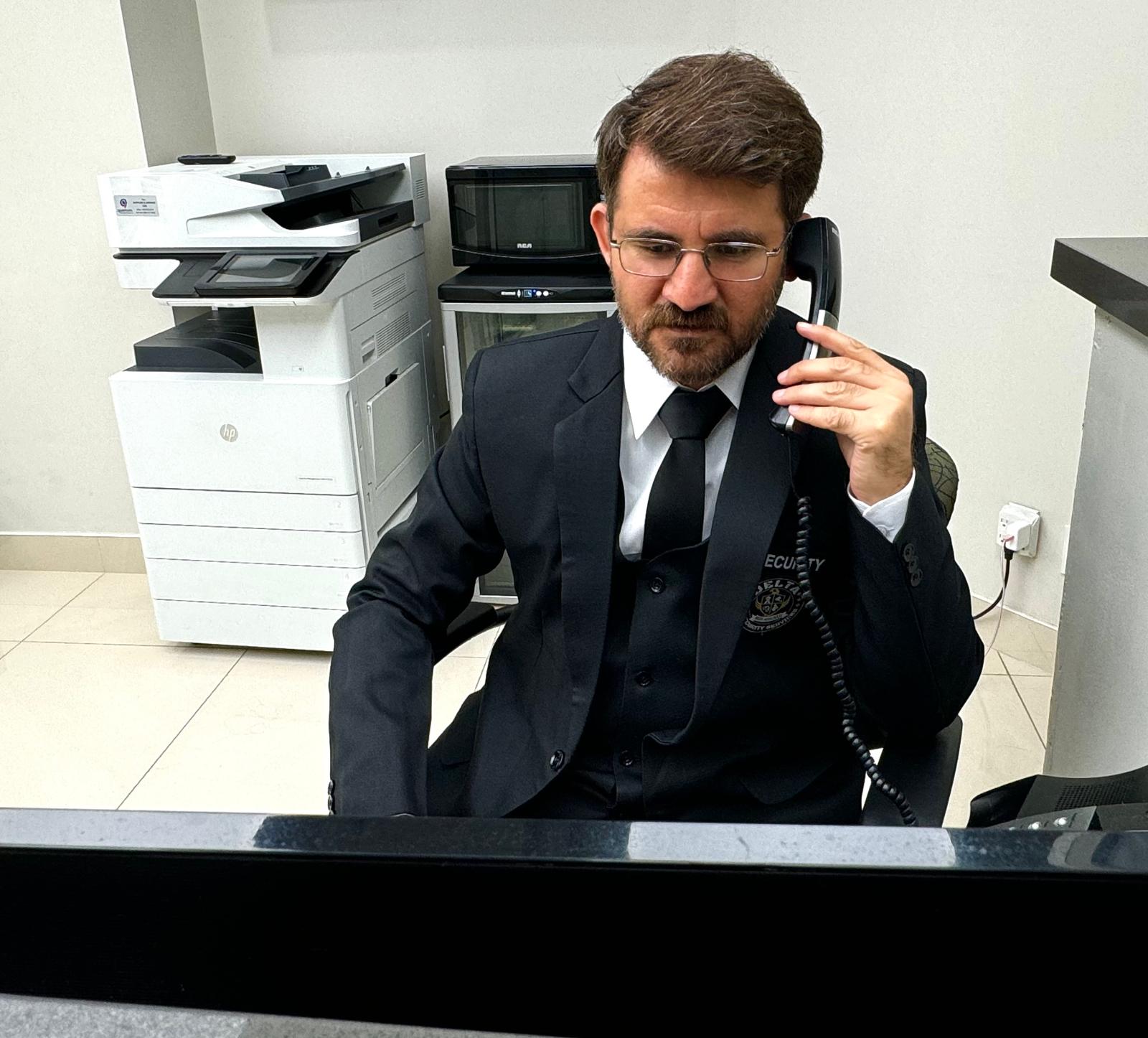 Delta Security dispatch officer in three-piece suit on duty